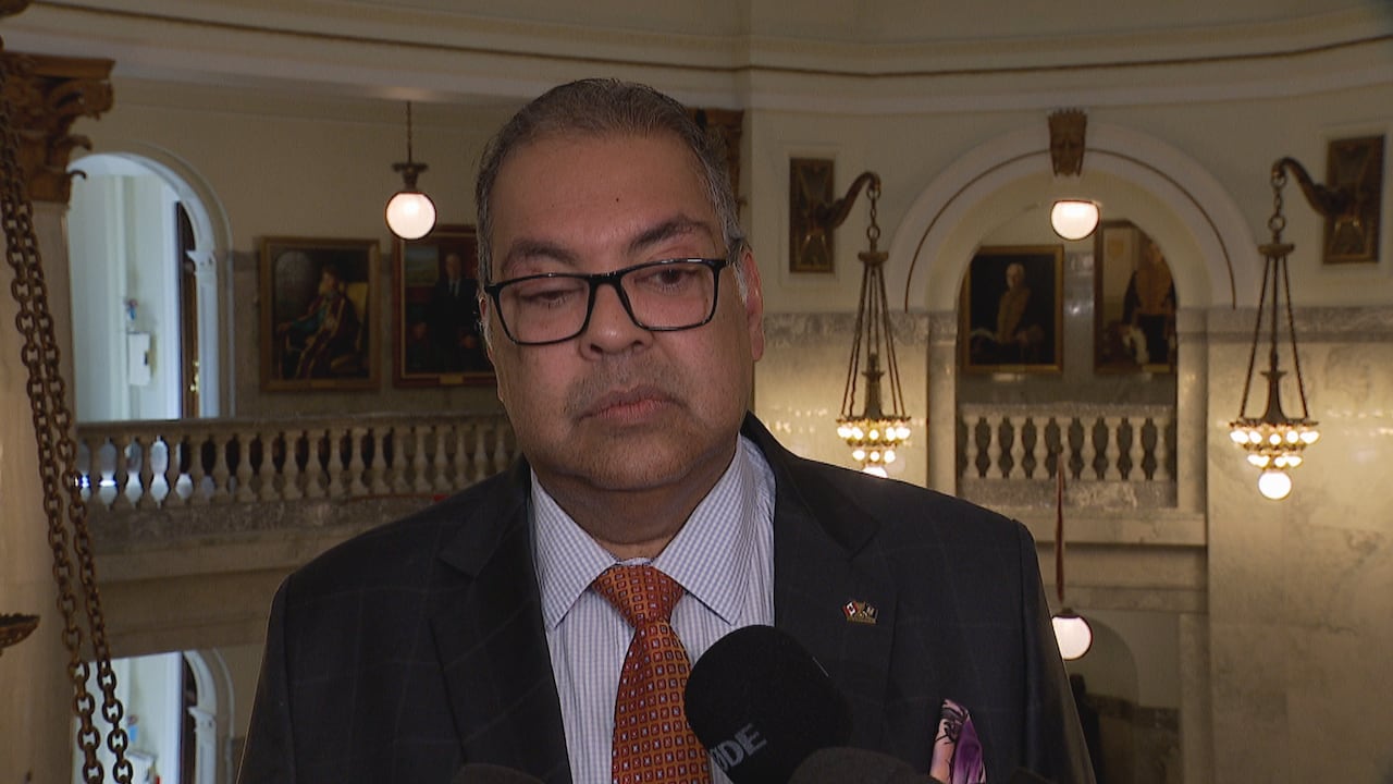 A man stands wearing a suit.