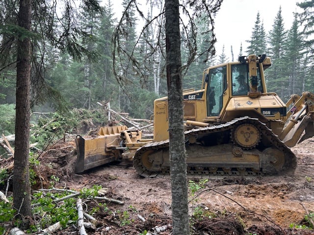 A bulldozer working in a forested area.