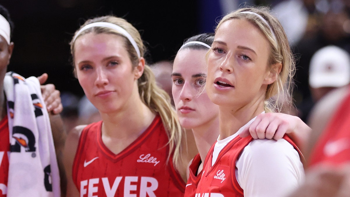Lexie Hull, Caitlin Clark, and Sophie Cunningham watching Golden State Valkyries celebrate at Chase Center
