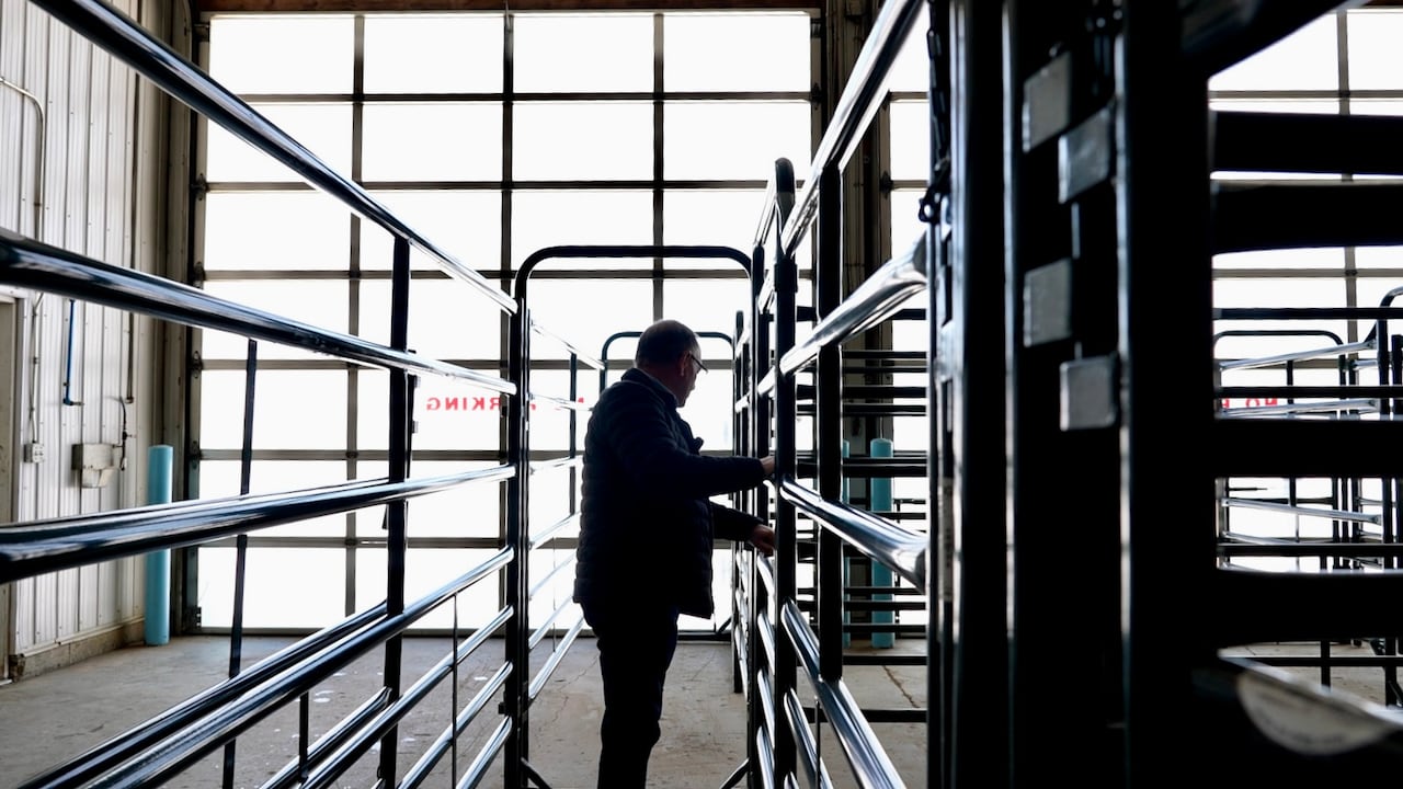 Man standing inside a steel fencing frame.