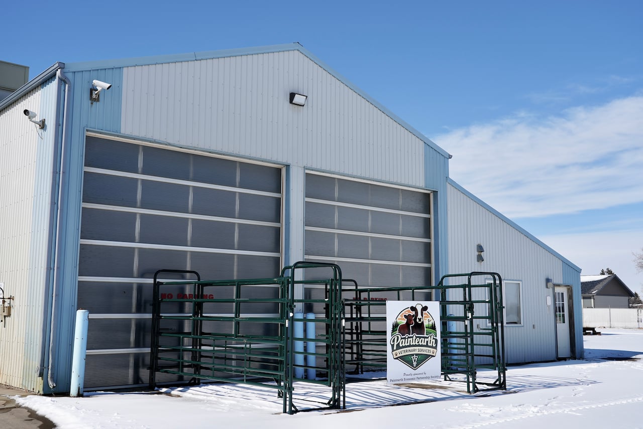 A warehouse-type building with some snow in the front.