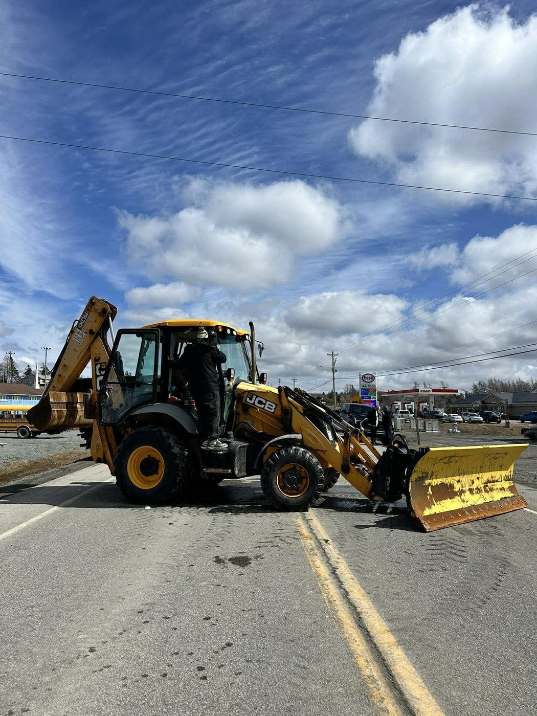 A tractor sits sideways on a road