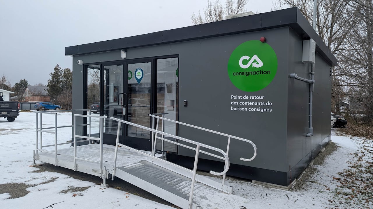 A small container-like kiosque where people can redeem bottles is seen in a snowy parking lot.