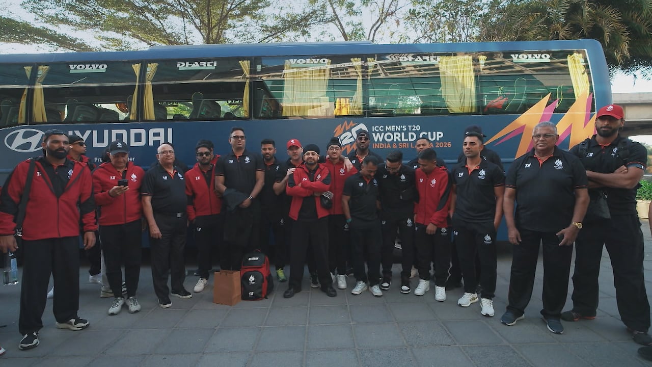 Cricket Canada’s men’s national team poses in front of a bus following their first match in Ahmedabad at the T-20 men’s World Cup.