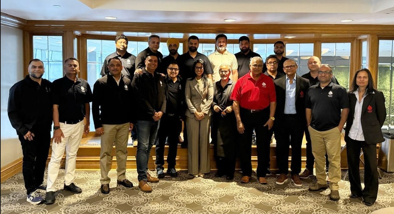 A group representing Cricket Canada’s previous board of directors line up for a photo in a hotel boardroom in Montreal.