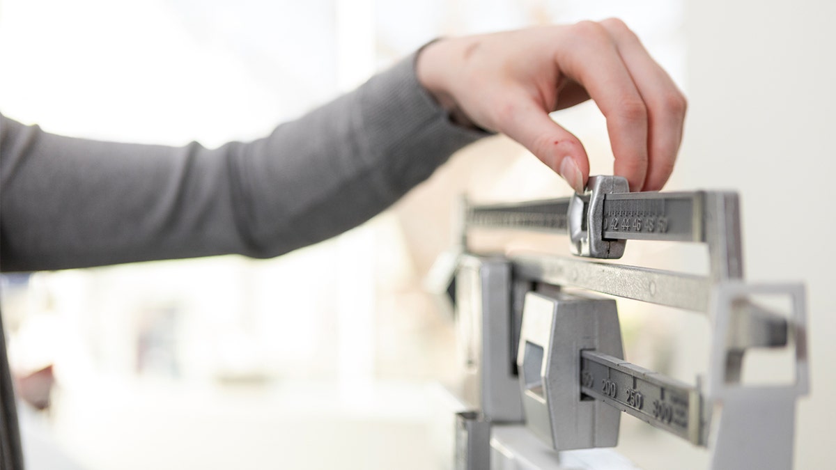 Woman weighing herself on a scale in a bathroom