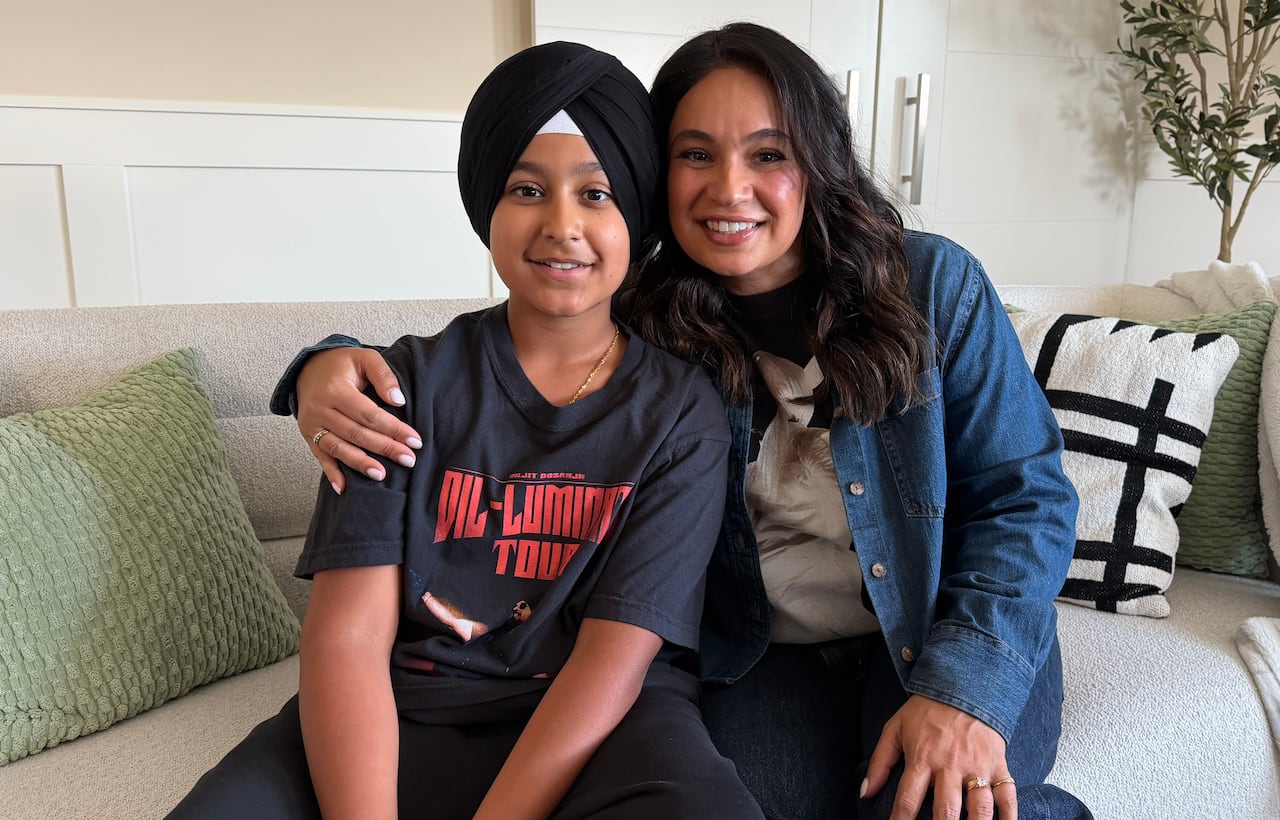 A mom and son pose for a photo. The son is wearing a music concert t-shirt.
