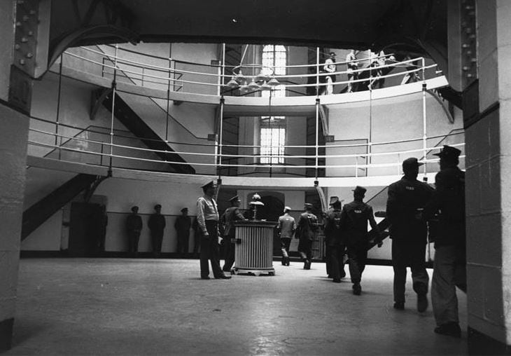 Inmate movement in the Main Dome. Circa-1950s. Inmates are returning to their cells with their meals.