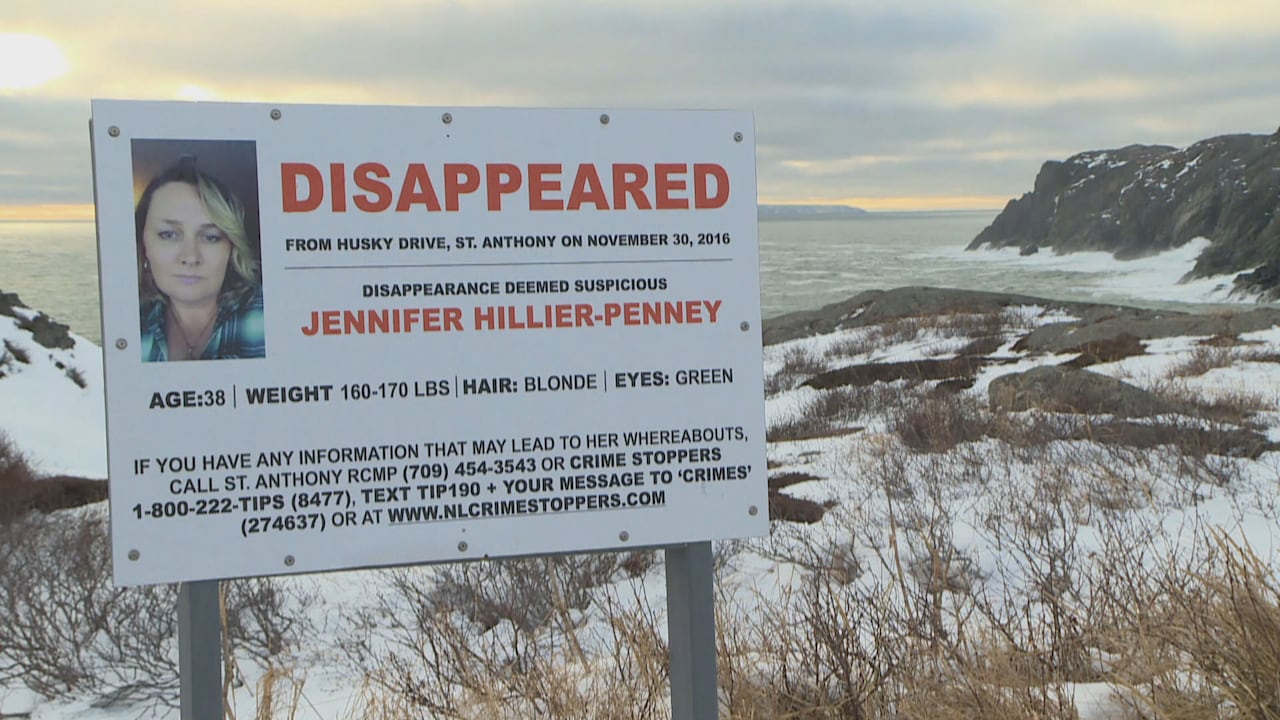 A missing notice is posted on a large sign near a wintry cliff.