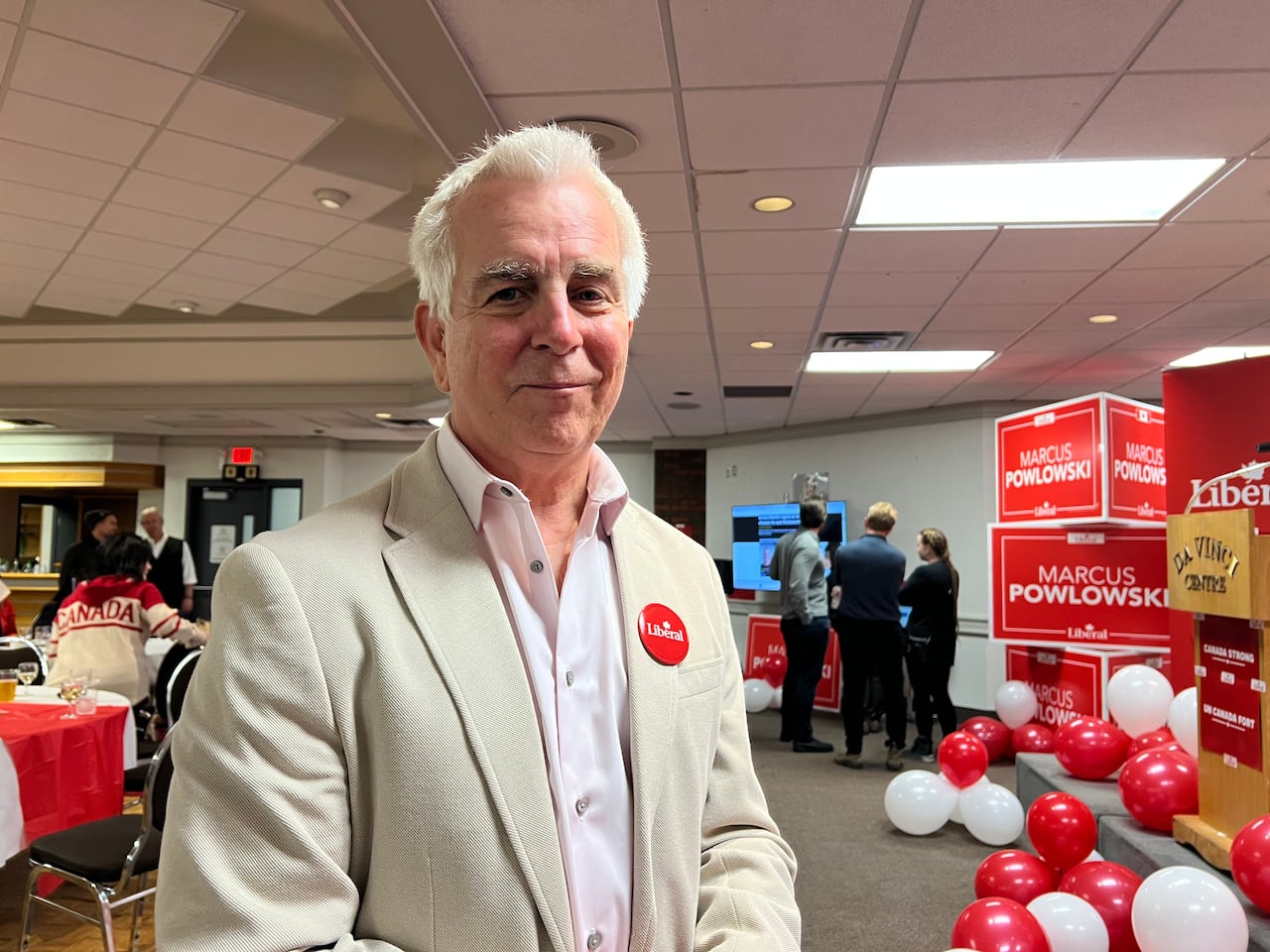 A man in a suit poses for a photo.