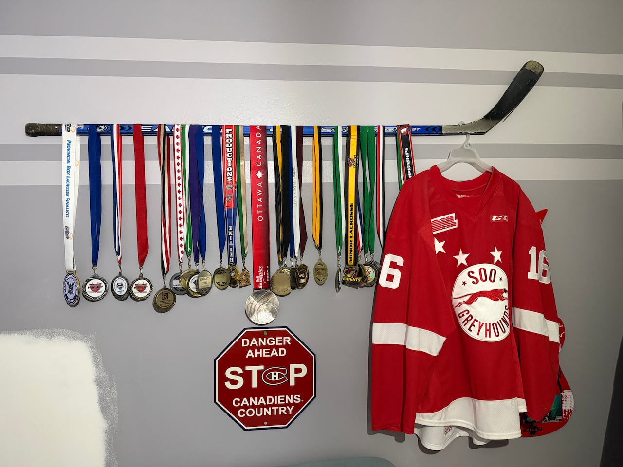 Medals and hockey memorabilia hang on a wall