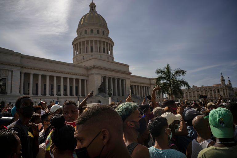 People protest in front of the Capitol in Havana, Cuba, Sunday, July 11, 2021. Hundreds of demonstrators went out to the streets in several cities in Cuba to protest against ongoing food shortages and high prices of foodstuffs, amid the new coronavirus crisis. (AP Photo/Ramon Espinosa)