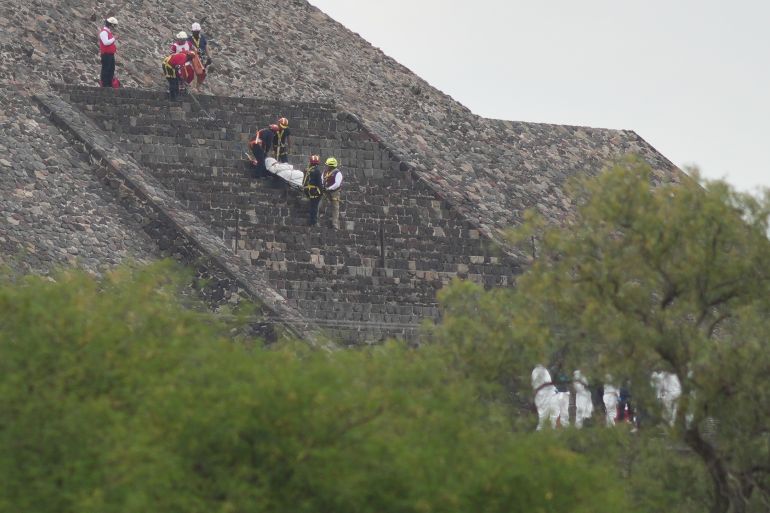 Forensic workers carry the body of a victim down a pyramid after authorities said a gunman opened fire, in Teotihuacan, Mexico, Monday, April 20, 2026. (AP Photo/Eduardo Verdugo)
