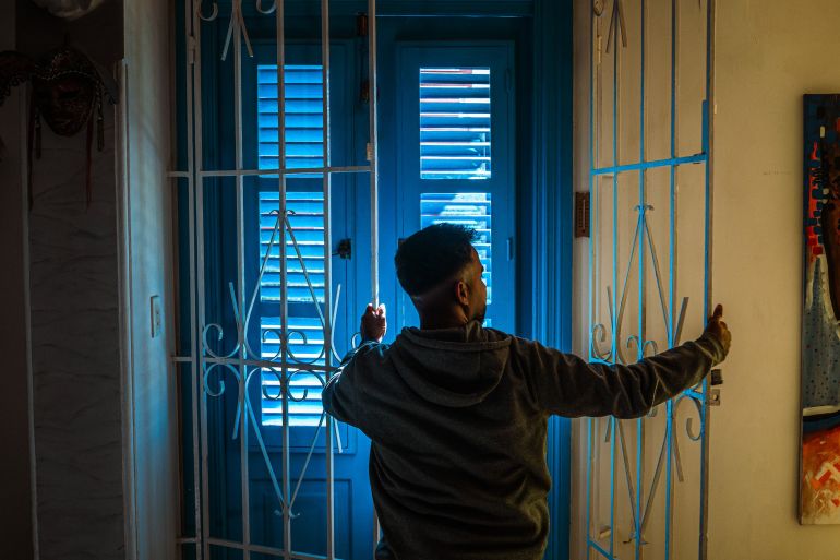 A man closes a gate to an Airbnb rental