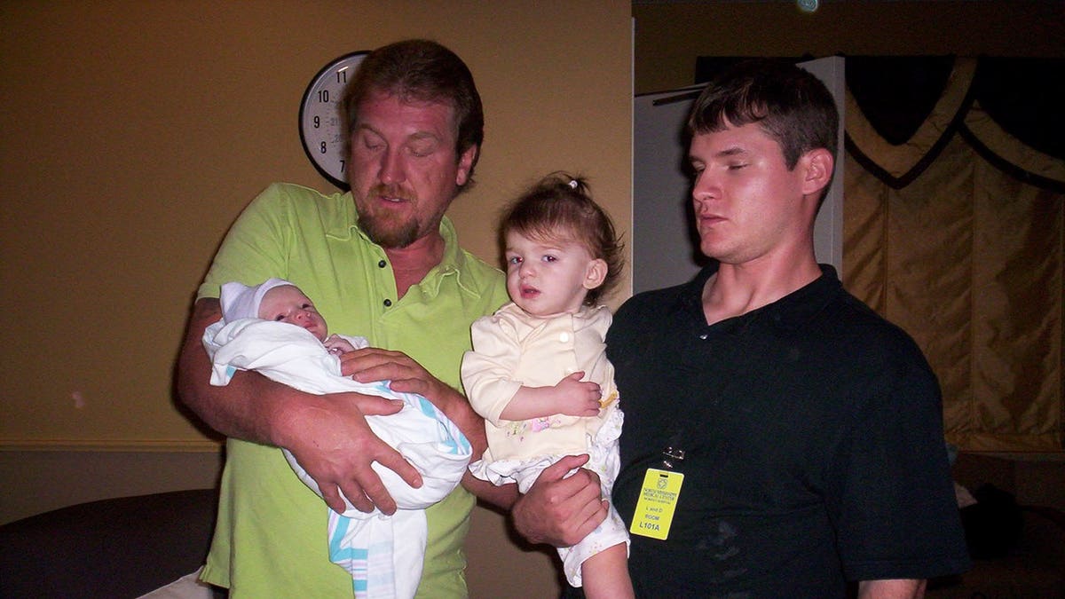 Timothy Jones Sr. holding one grandchild while Timothy Jones Jr. holds another.
