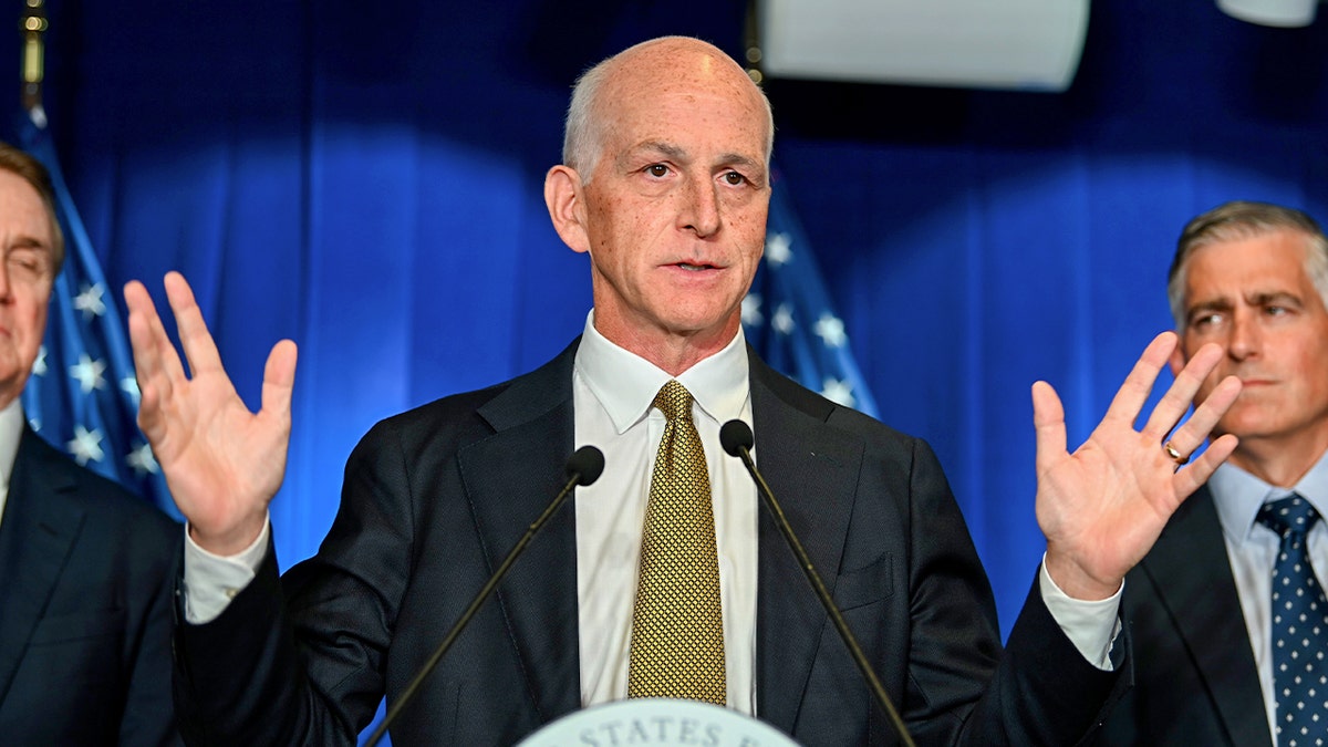 Adam Smith speaking to journalists