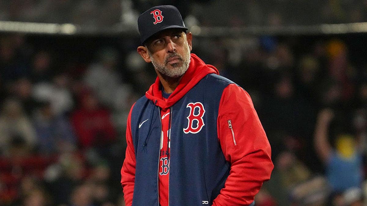 Boston Red Sox manager Alex Cora returning to the dugout at Fenway Park.