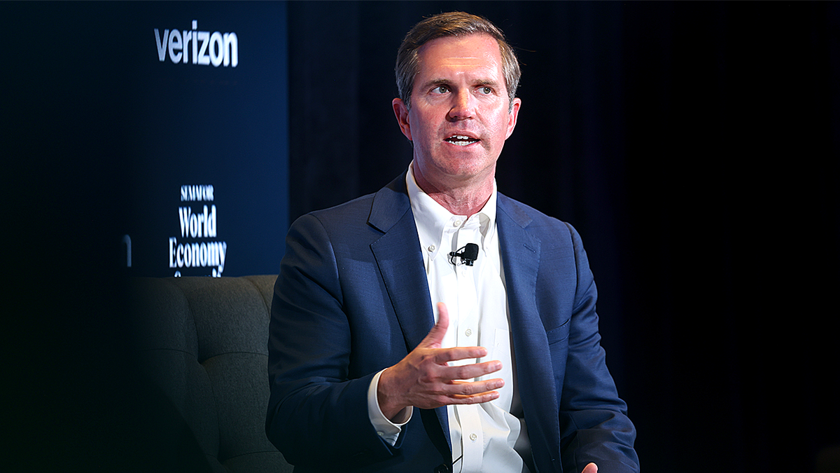 Kentucky Gov. Andy Beshear speaking with hand raised at a summit in Washington, D.C.