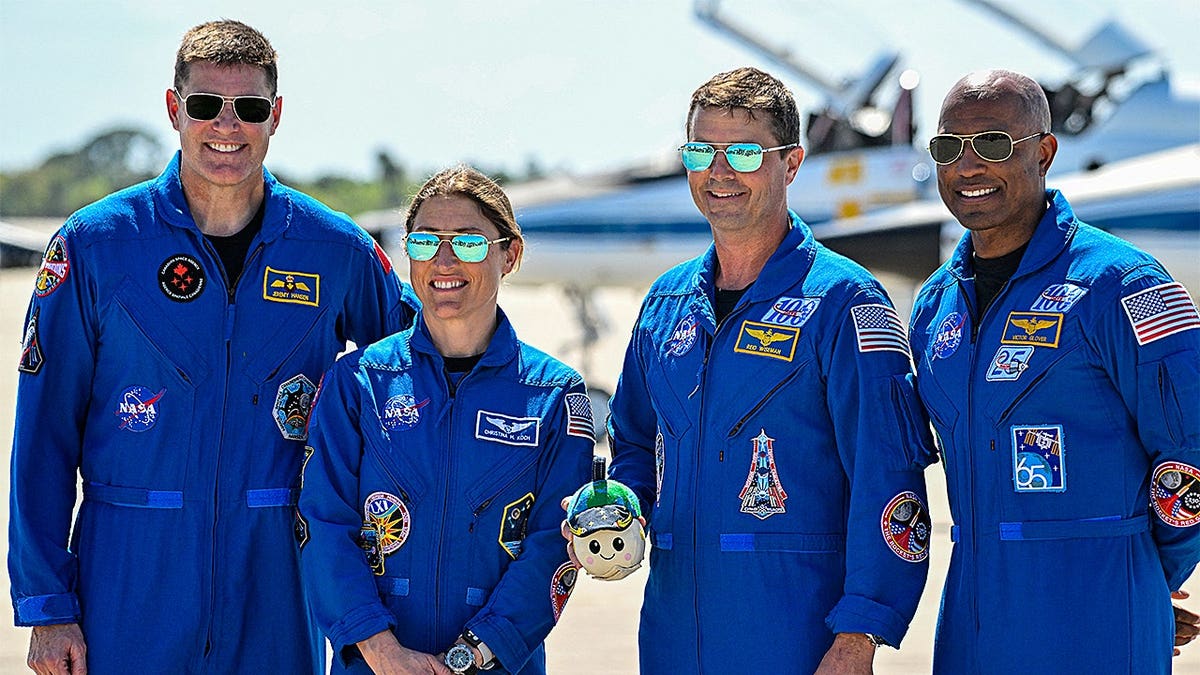 Astronauts Jeremy Hansen, Christina Koch, Reid Wiseman, and Victor Glover standing together at Kennedy Space Center
