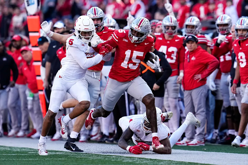 Ohio State Buckeyes tight end Jelani Thurman (15) runs past Rutgers Scarlet Knights defensive back Kaj Sanders (5) during the second half of the NCAA football game at Ohio Stadium in Columbus on Nov. 22, 2025. Ohio State won 42-9.