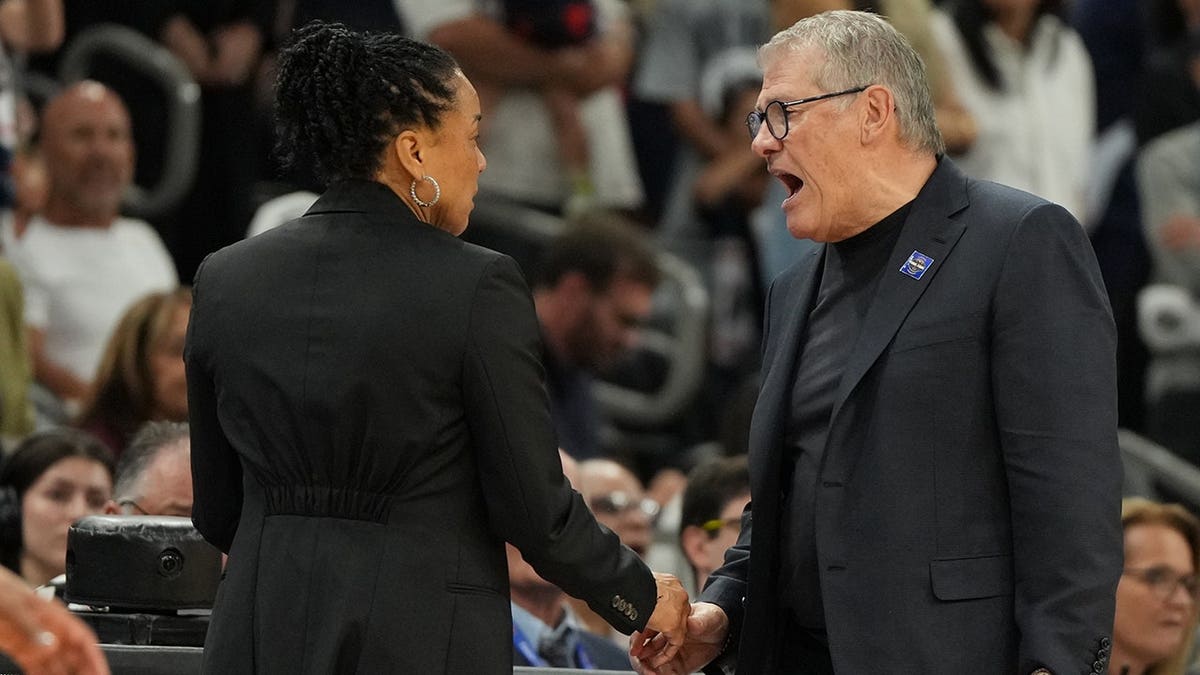 South Carolina head coach Dawn Staley and UConn head coach Geno Auriemma arguing on basketball court