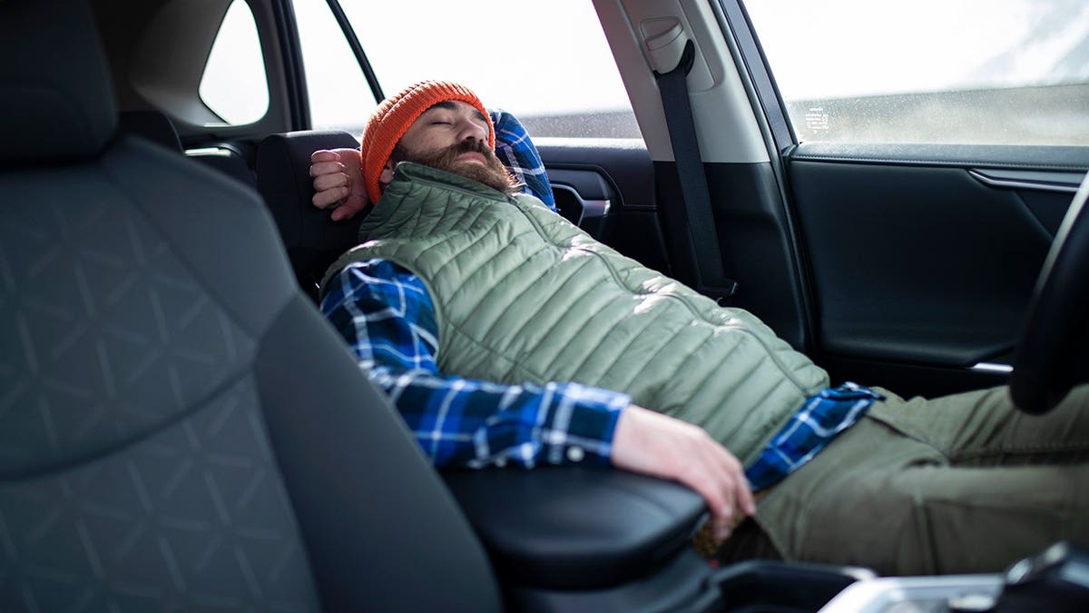 A man sleeping inside a car