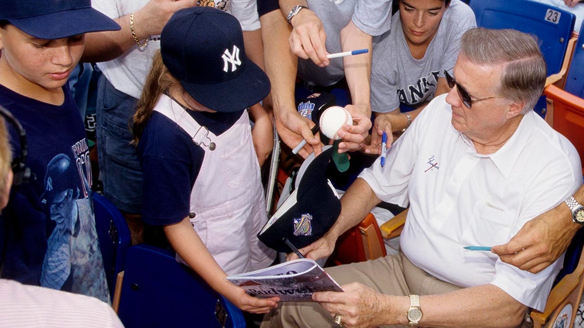 George Steinbrenner signs autographs