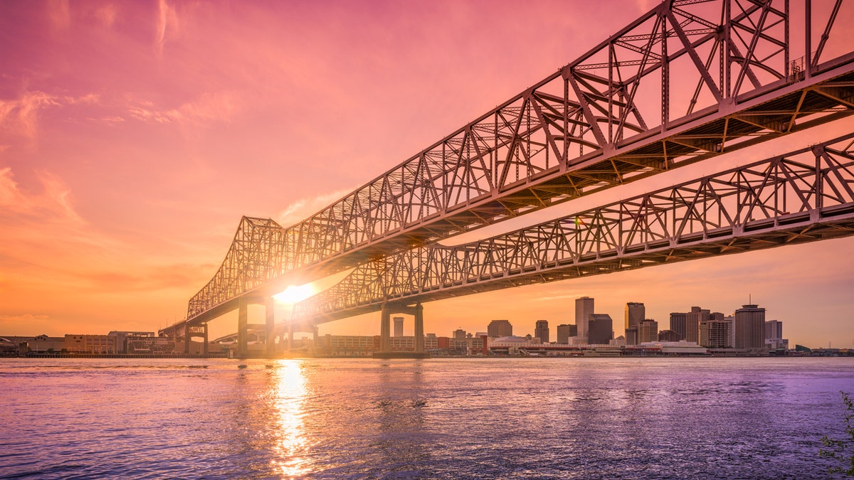 New Orleans, Louisiana, USA at Crescent City Connection Bridge over the Mississippi River during sunset.