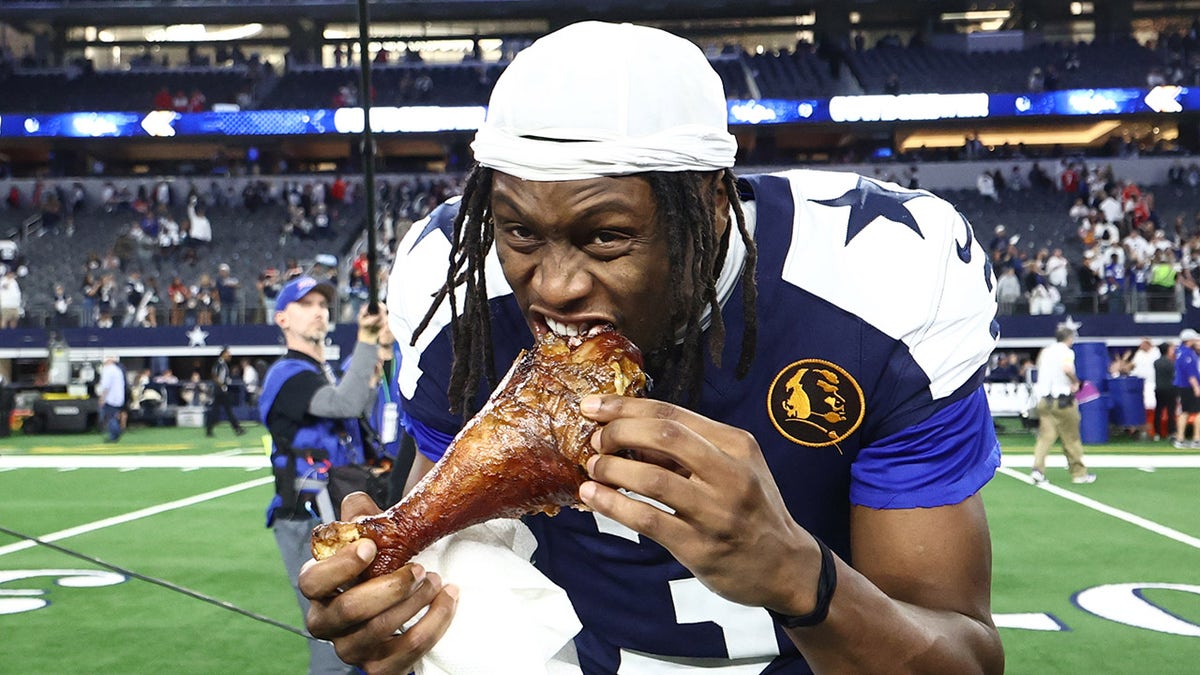 Dallas Cowboys wide receiver George Pickens eating turkey in celebration at AT&T Stadium