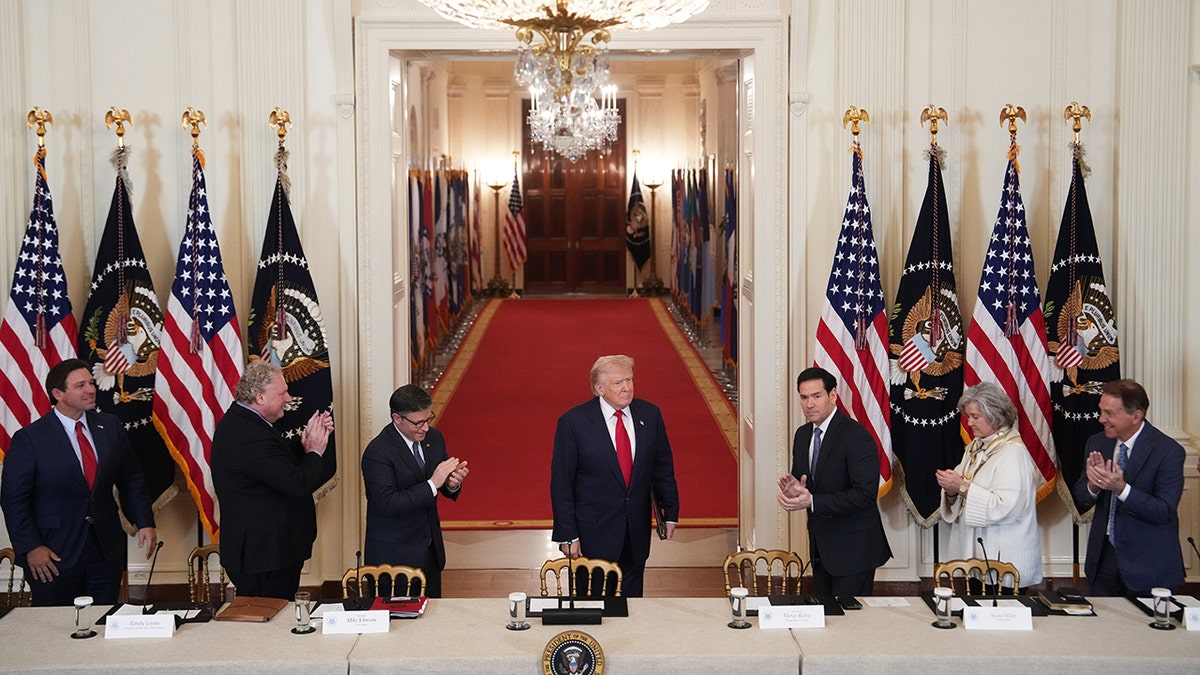 President Donald Trump walking into the East Room of the White House