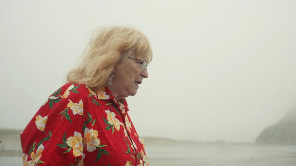 Richard Russell's mother in a red floral shirt looking away from the camera.