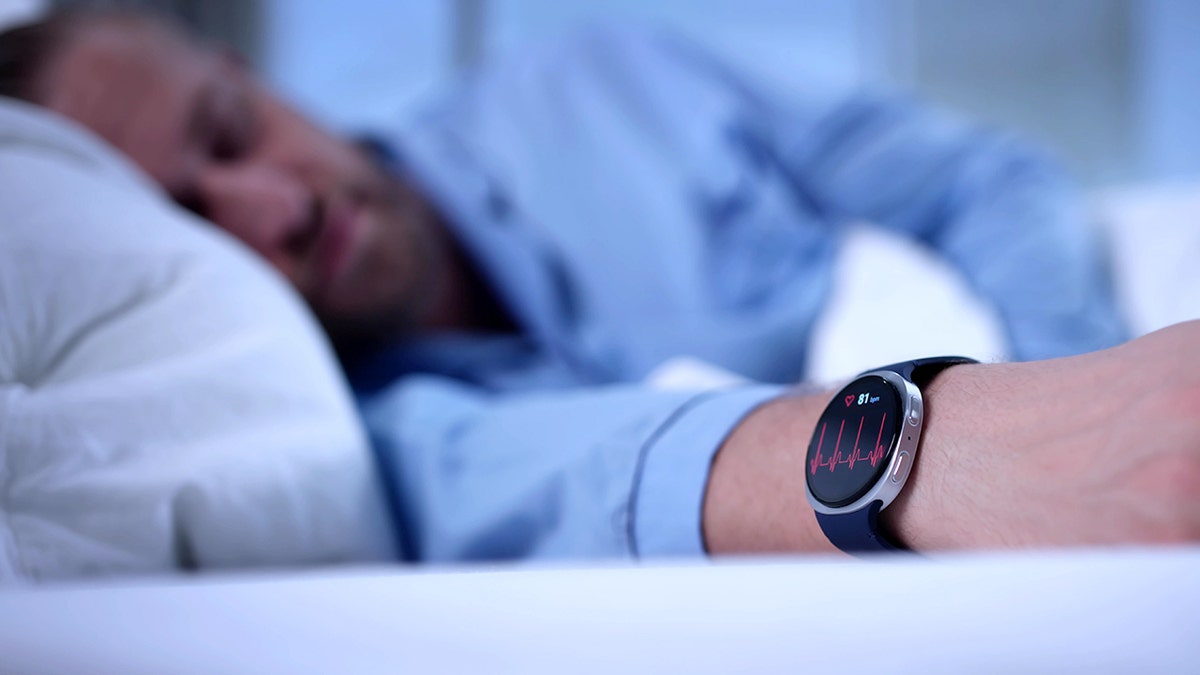 A man sleeping while wearing a smartwatch on his wrist