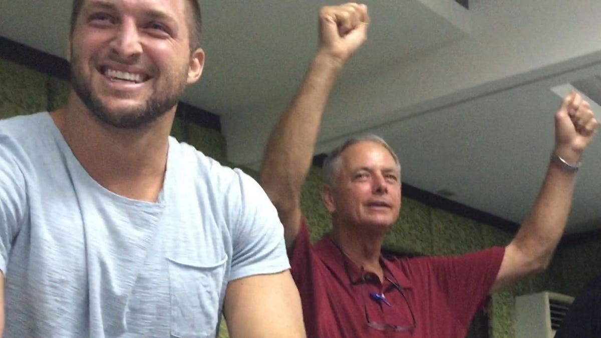 Tim Tebow and dad, Bob, seen laughing and cheering together in social media photo.
