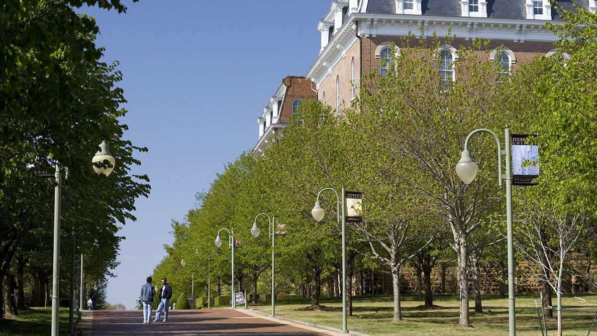 Students talking behind Old Main building at University of Arkansas campus