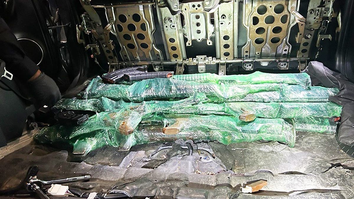 Guns and other weapons are hidden in the back seat of a Lexus, wrapped in green plastic wrap