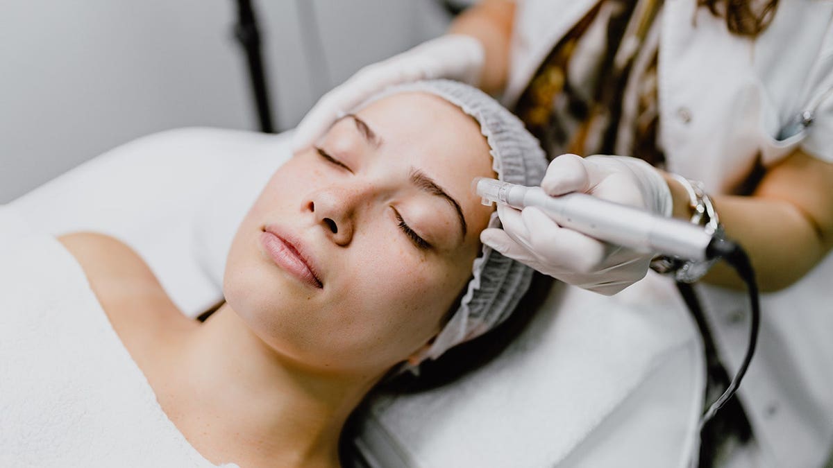 woman receiving micro-needling collagen facial treatment in clinic