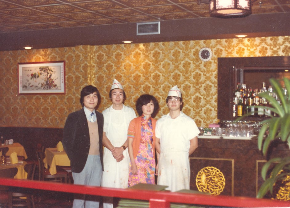 A photo from 1979 shows a man in a suit, two men wearing chefs aprons and a woman standing in a restaurant.