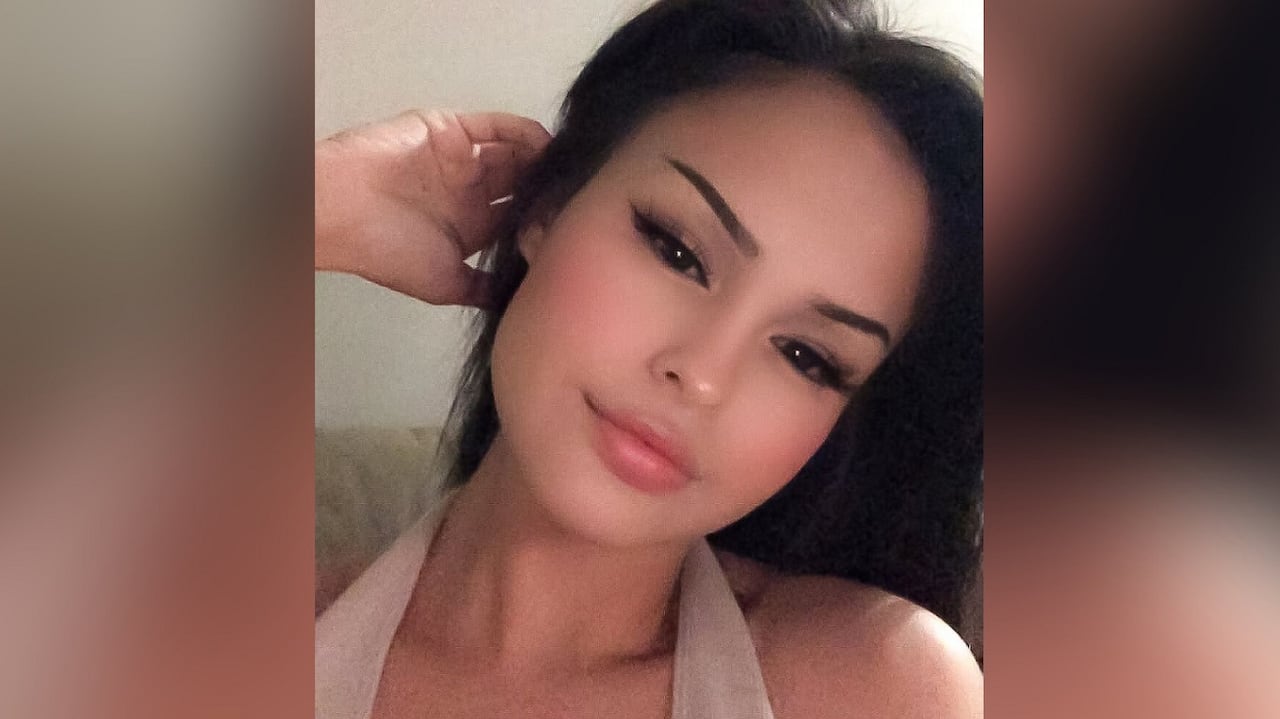 A woman with long black hair takes a selfie.