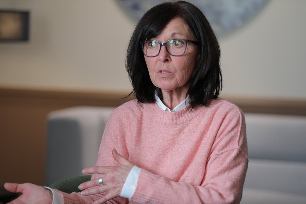 A woman in a pink sweater and white shirt tells her story to CBC News.