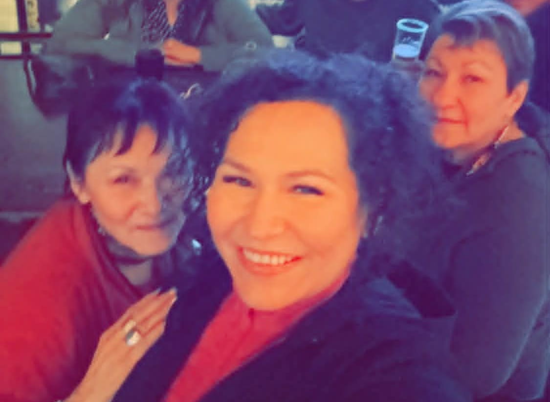 Women smile for a selfie.