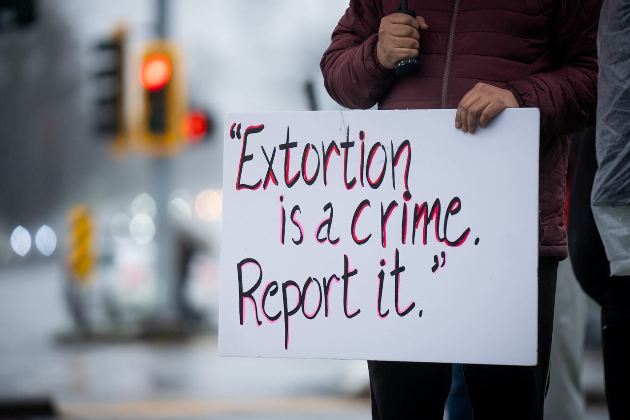 Surrey residents hold signs during a demonstration against extortion-related violence in Surrey, British Columbia, on Monday, Feb., 2, 2026.
