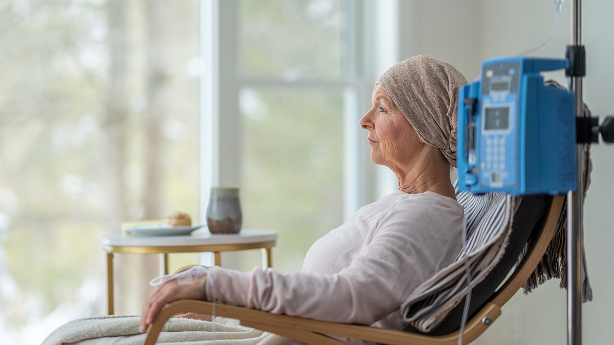 Senior woman sitting in her home receiving chemotherapy treatment