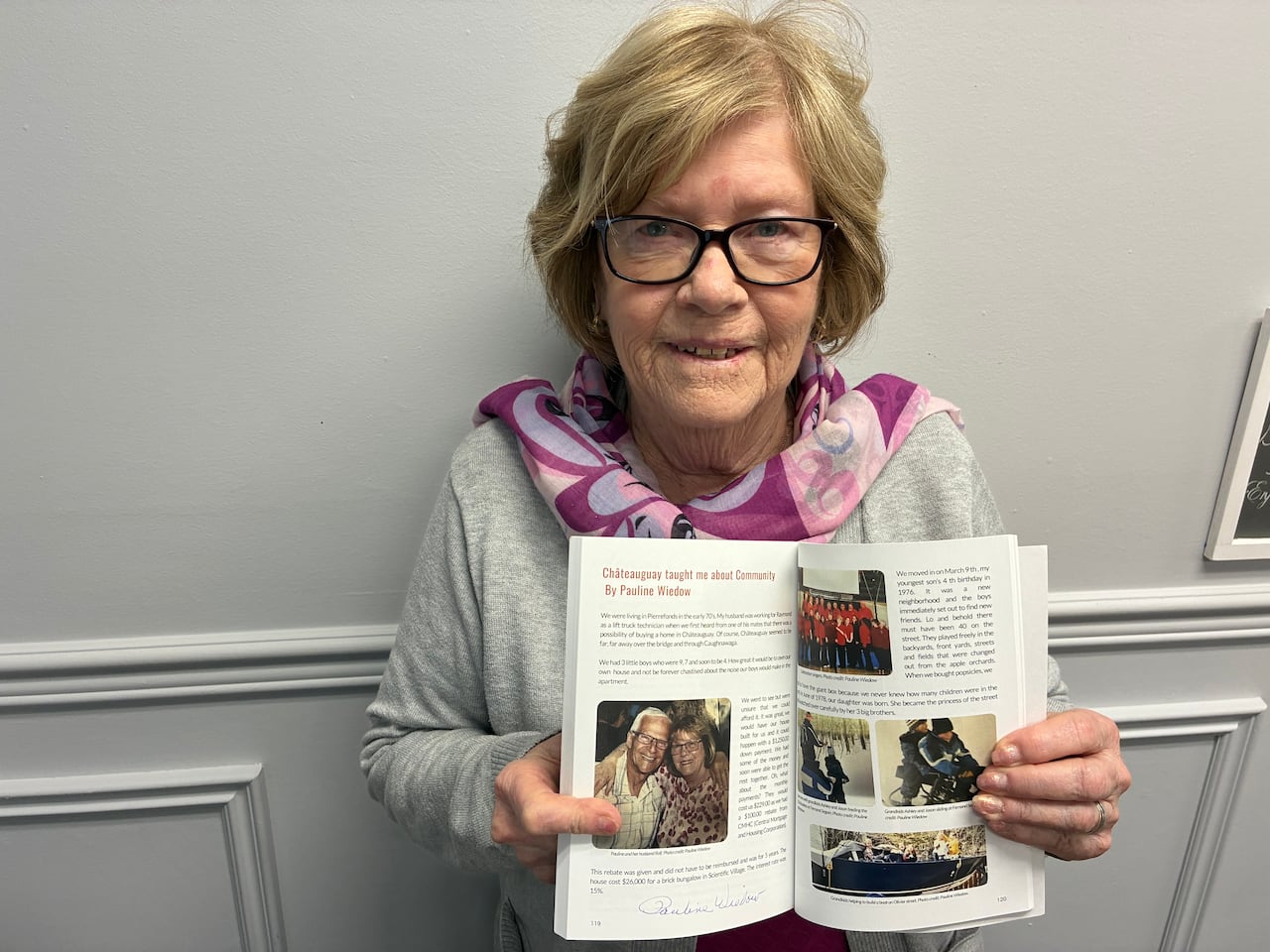 Pauline Wiedow opens the book to show the pages that she helped contribute to the collection of stores from residents