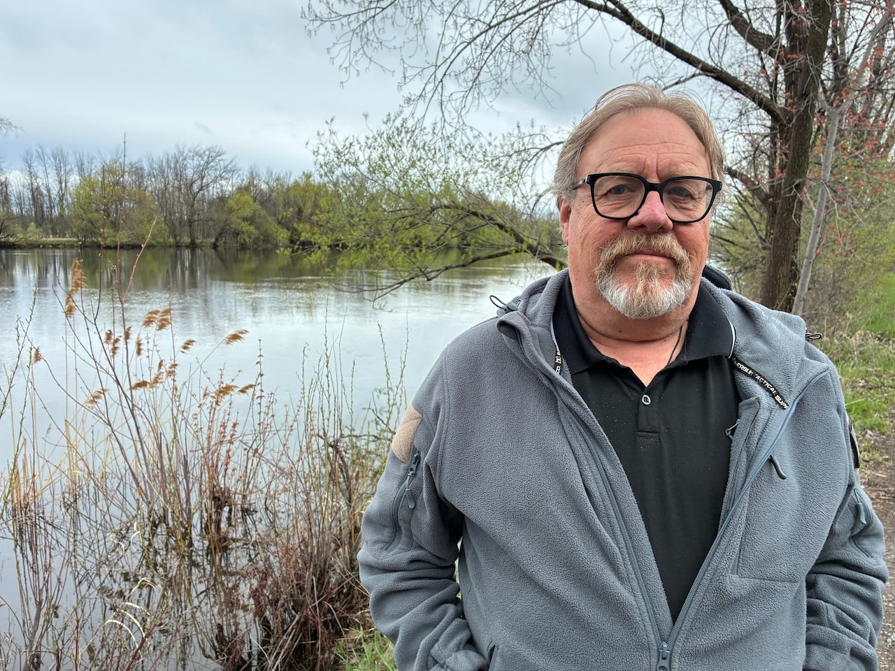 Georges Bujold stands in front of the Châteauguay River, responsible for yearly floods during his childhood.