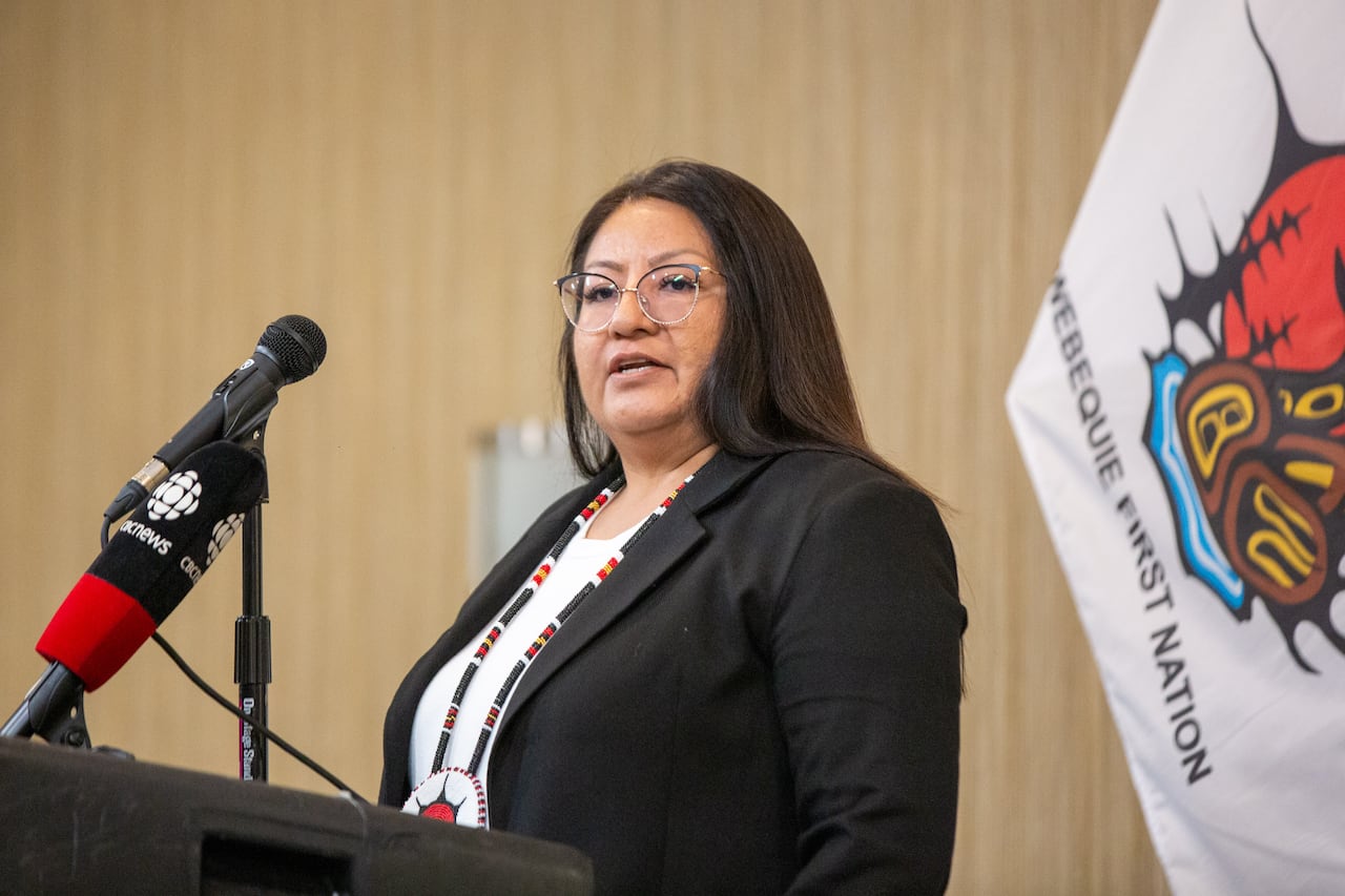 A person is seen speaking into a microphone at a podium.