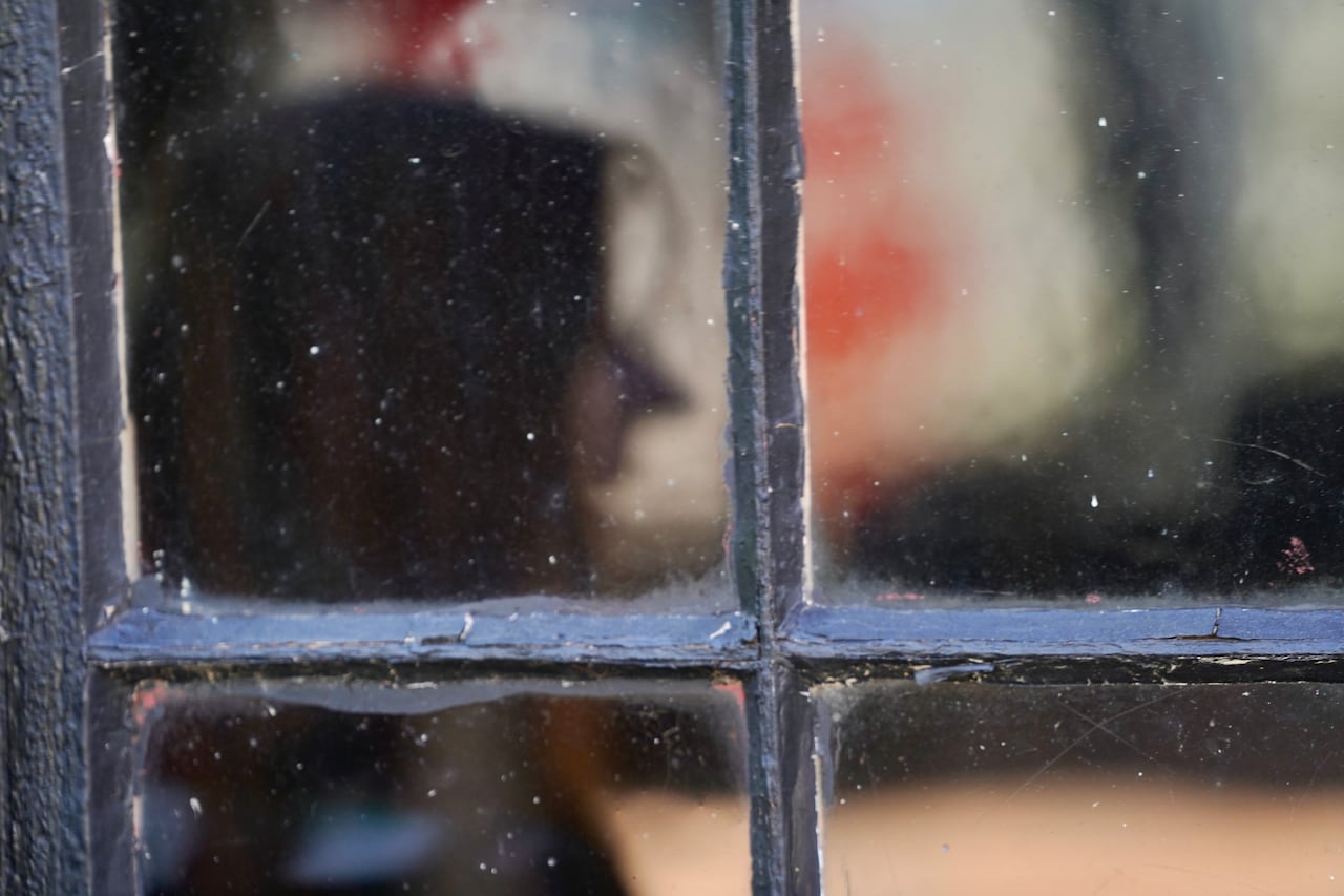 An anonymous woman is depicted through glass.