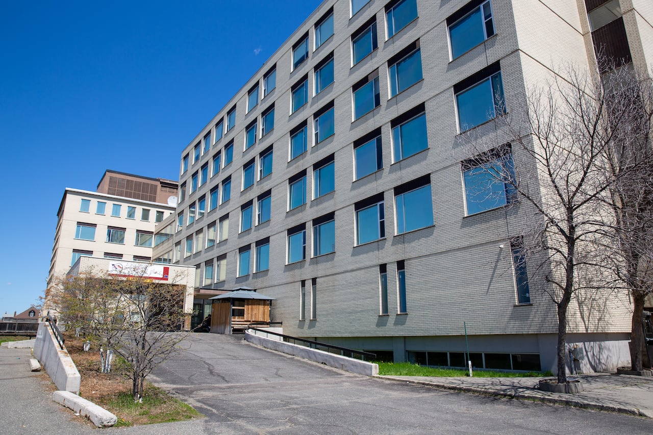 A wide shot of a white-brick building.