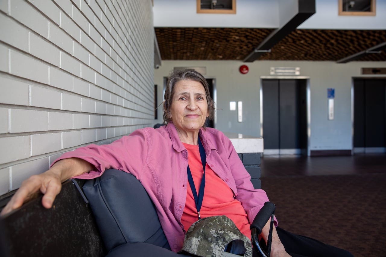 A person is seen on a couch in a lobby.