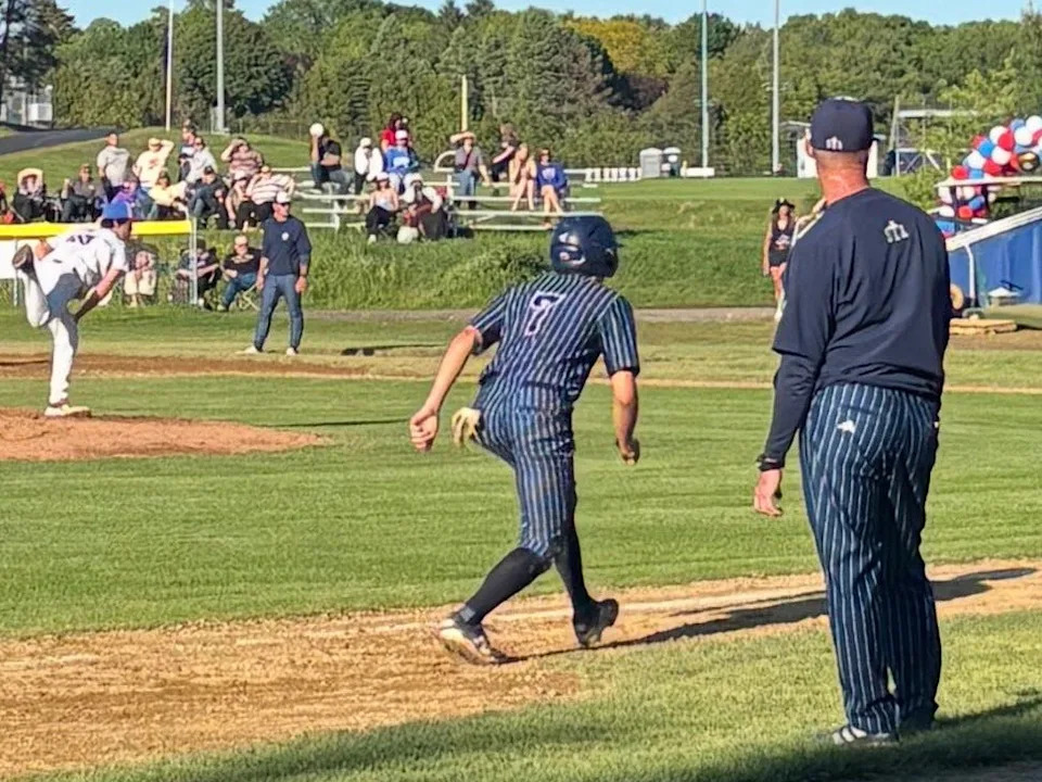 St. Thomas Aquinas junior Conall Ciaschini takes a lead off third base as Winnacunnet's Oscar Fritz delivers a pitch during Monday's high school baseball game in Hampton. St. Thomas Aquinas won 11-4.