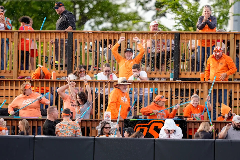 Oklahoma state fans spray water to celebrate a home run during of a college softball game between the Oklahoma State Cowgirls and the Kansas Jayhawks in Stillwater, Friday, May 1, 2026.